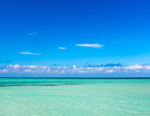 Wall Mural - clouds on blue sky over calm sea with sunlight reflection