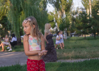portrait of a child, girl 6 years old, blonde, played in the playground, in the park
