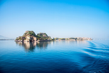 Wall Mural - view of the fortress of corfu from the sea in the morning mist with a trace of waves from the ferry.