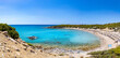 Crystal clear turquoise water in a Glystra beach. Cane umbrellas and sunbeds on an beach resort - vacation concept on Greece islands in Aegean and Mediterranean sea. Near Lindos at east Rhodes. Greece