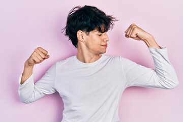 Sticker - Handsome hipster young man wearing casual white shirt showing arms muscles smiling proud. fitness concept.