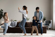© fizkes - Excited happy family dancing to music in living room, having fun together, enjoying home party, activities and exercises. Couple of parents and funny energetic kids celebrating new house buying