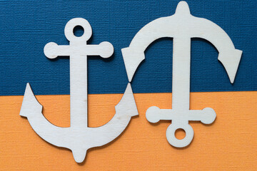 two laser-cut plywood anchor shapes on an orange and navy blue paper background