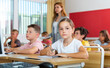 © JackF - Group portrait of positive school children with teacher posing together in classroom at elementary school