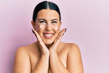 Poster - Beautiful brunette woman standing topless wearing face cream smiling with a happy and cool smile on face. showing teeth.