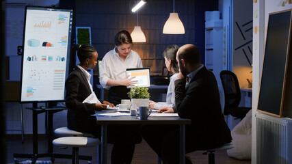 Wall Mural - diverse multi-ethnic businesspeople analyzing management graphs using tablet for company presentatio
