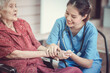 © chompoo - Asian eldery  woman with her caregiver at home. Home care or Elderly care concept.
