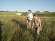 © Evgeny Korshenkov - Mother and daughter are walking in the hills and take wild flowers in a bouquet.