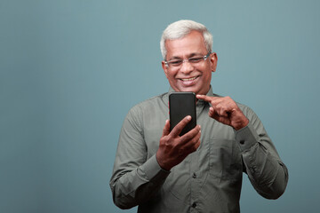 Wall Mural - A happy man of Indian ethnicity with a smiling face engaging his mobile phone