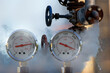 © Mike Mareen - water pressure gauge meters against a leaky pipeline which comes out hot steam and hot water under pressure