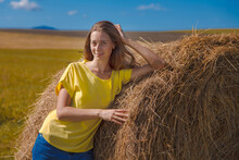 A Girl Is Sunbathing In The Hay. Village Life: Harvesting Hay For The Winter. Animal Feed.