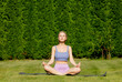 © Masson - Girl practices yoga in the backyard of her house