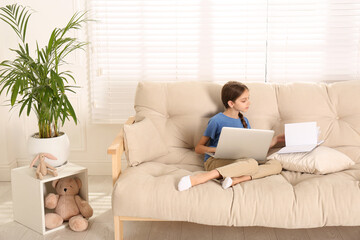 Poster - Girl with laptop and book on sofa at home