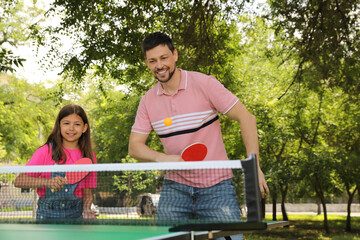 Sticker - Happy man with his daughter playing ping pong in park