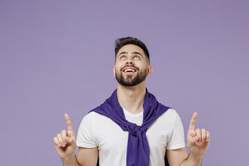 Wall Mural - Young brunet man 20s wears white t-shirt purple shirt point look up above on workspace area copy space mock up isolated on pastel violet background studio portrait. People emotions lifestyle concept.