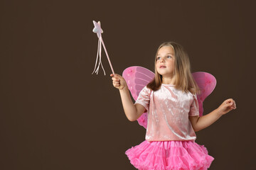 Canvas Print - Cute little girl in fairy costume with wings and magic wand on brown background. Space for text