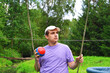 Autistic behavioral traits.A beautiful autistic guy rides with a ball on a swing in the park among the trees