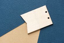 Plain Wooden Tag On Beige And Navy Blue Patterned Paper Background