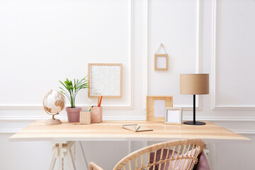 Wooden table with desk lamp in room. Interior design