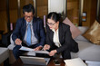 © DragonImages - Senior CEO and CFO analyzing and discussing reports with charts and diagrams at meeting