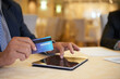 © DragonImages - Close-up image of senior entrepreneur with credit card shopping online and paying with credit card