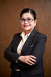 © DragonImages - Portrait of smiling elegant senior female entrepreneur standing with arms crossed and looking at camera
