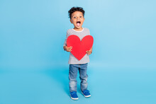Full Length Body Size View Of Nice Funny Cheerful Amazed Boy Holding Paper Heart Isolated Over Bright Blue Color Background