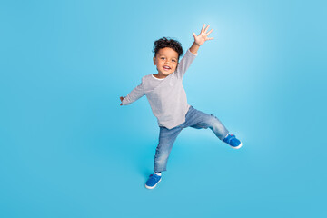 Full length body size view of attractive cheerful carefree boy dancing good mood isolated over bright blue color background