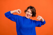 © deagreez - Photo of funny brunette short hairdo millennial lady yell wear blue sweater isolated on orange color background