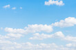 Panorama of delicate blue sky with soft puffy white clouds, summer day sunlight