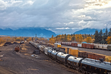 Wall Mural - rail yard, Whitefish, Montana on a fall morning with heavy clouds and mountains in background