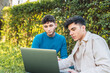 © ADDICTIVE STOCK - Male freelancers working on laptop together in park