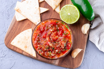 Wall Mural - Traditional Tex-Mex cuisine salsa Asada sauce with roasted vegetables, served with tortilla chips and lime, horizontal, top view