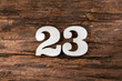 Number twenty three 23 - White Piece on Rustic Wood Background