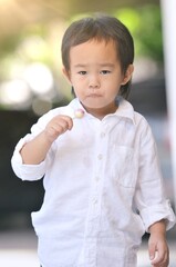 Little Asian boy with lollipop at outdoor , Happy 4 years asian boy with a lollipop on a sunny day in the garden at home.Happy and Delicious face with candy lollipop concept.