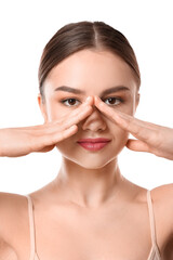 Wall Mural - Beautiful young woman massaging her face on white background