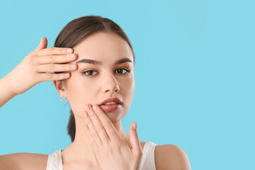 Sticker - Beautiful young woman massaging her face on color background