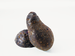 Wall Mural - Two Dark Purple Shetland Black Potatoes Isolated on White Background. Vegetable still life for food from Hügelkultur no-dig raised bed.