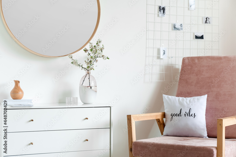 Vase with blossoming branches in interior of stylish room