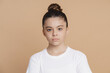 © speed300 - Serious teenage girl with a bundle of hair looks at the camera. Cute little girl on a pink background