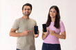 © IndiaPix - A young man and woman pointing to the mobile phones in their hands.