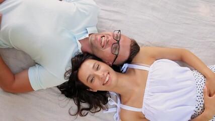 Poster - leisure, vacation and people concept - happy couple lying on picnic blanket