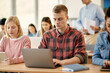 © Drazen - Male university student learns on laptop during class in classroom.