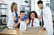 © sofiko14 - Four diverse multiracial genetics doctors scientists in uniforms waving to their colleague during video online conference, while working over joint research of structural DNA formula and drugs