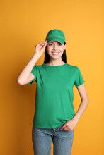 Young Happy Woman In Green Cap And Tshirt On Yellow Background. Mockup For Design