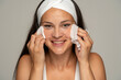 © vladimirfloyd - young happy woman with headband cleans her face with wet wipes