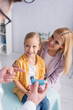 © LIGHTFIELD STUDIOS - Blurred family doctor pointing at inhaler near cheerful mother and girl