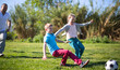 © caftor - Father with mother with two children enjoy playing soccer on lawn in summer park