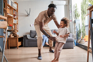 Wall Mural - Funny parent and cute little child girl laughing in modern living room