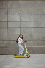 Young woman is riding a scooter